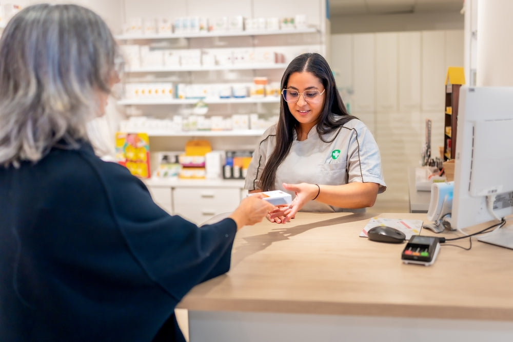 Customer interacting with a pharmacist at a pharmacy counter.